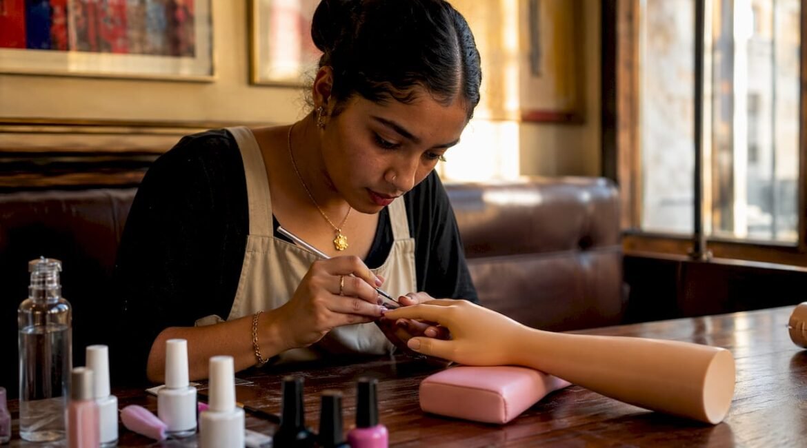 Una studentessa si esercita con la nail art durante una lezione a Milano.