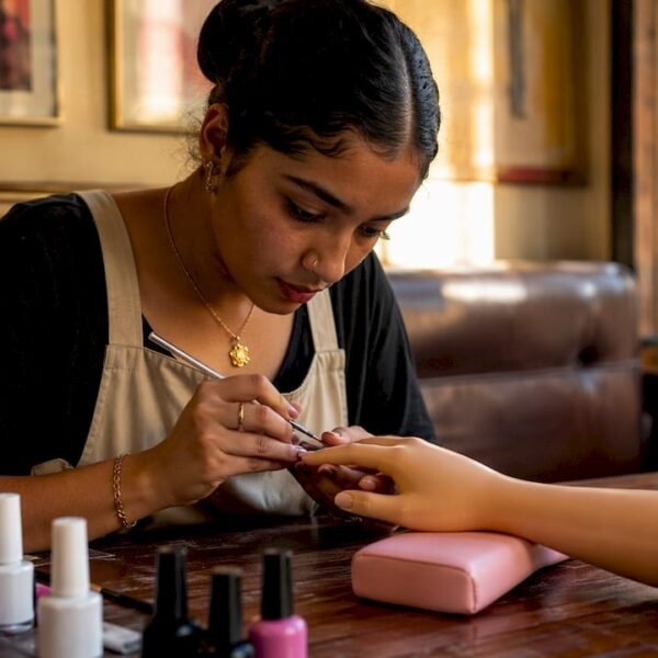 Una studentessa si esercita con la nail art durante una lezione a Milano.