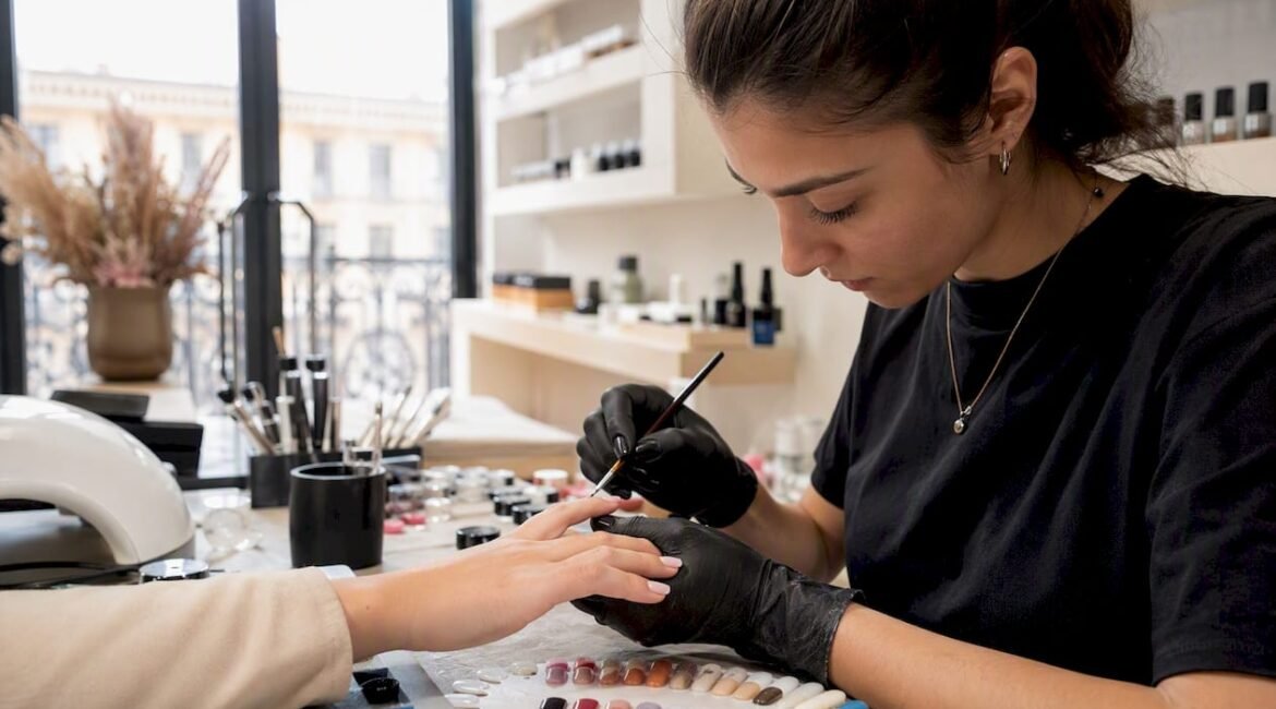 Un'estetista professionista mostra come applicare il gel alle unghie durante una lezione in aula.