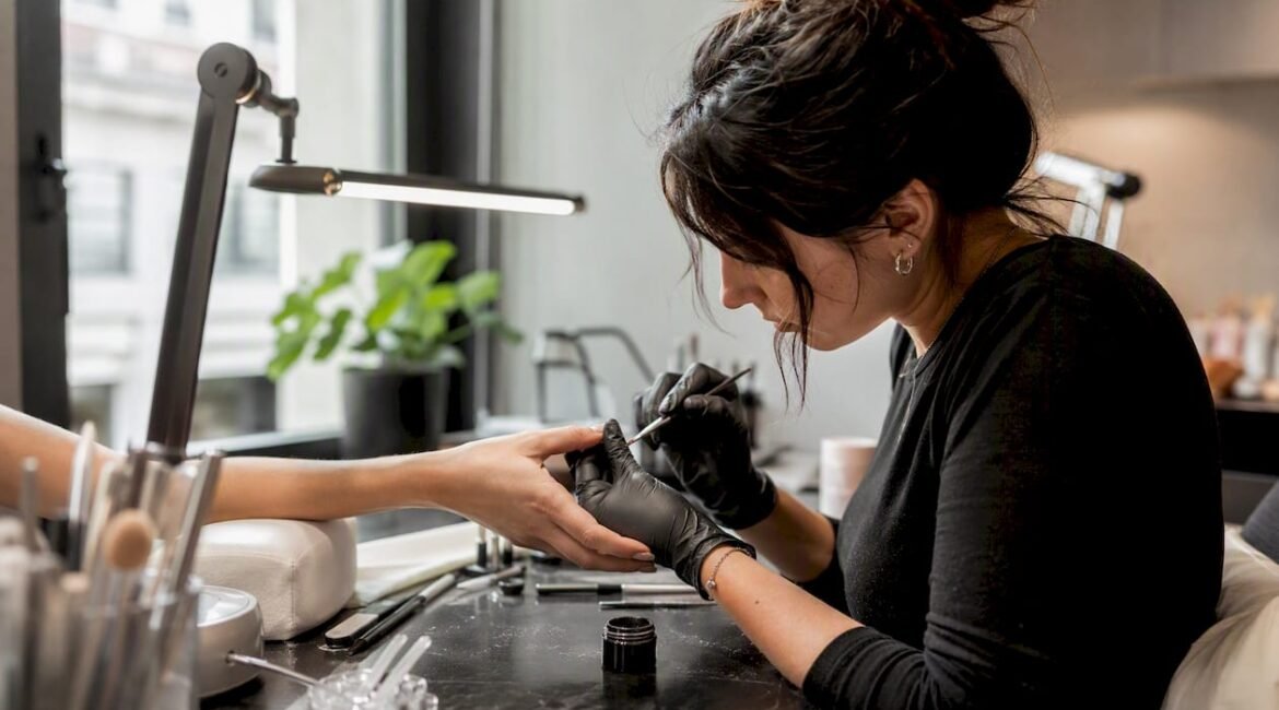 Una professionista sta applicando il gel sulle unghie di una cliente nel suo studio.