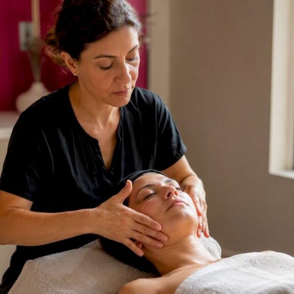 Una estetista esperta si prende cura del viso con un massaggio Kobido, regalando un momento di benessere e luminosità alla pelle.