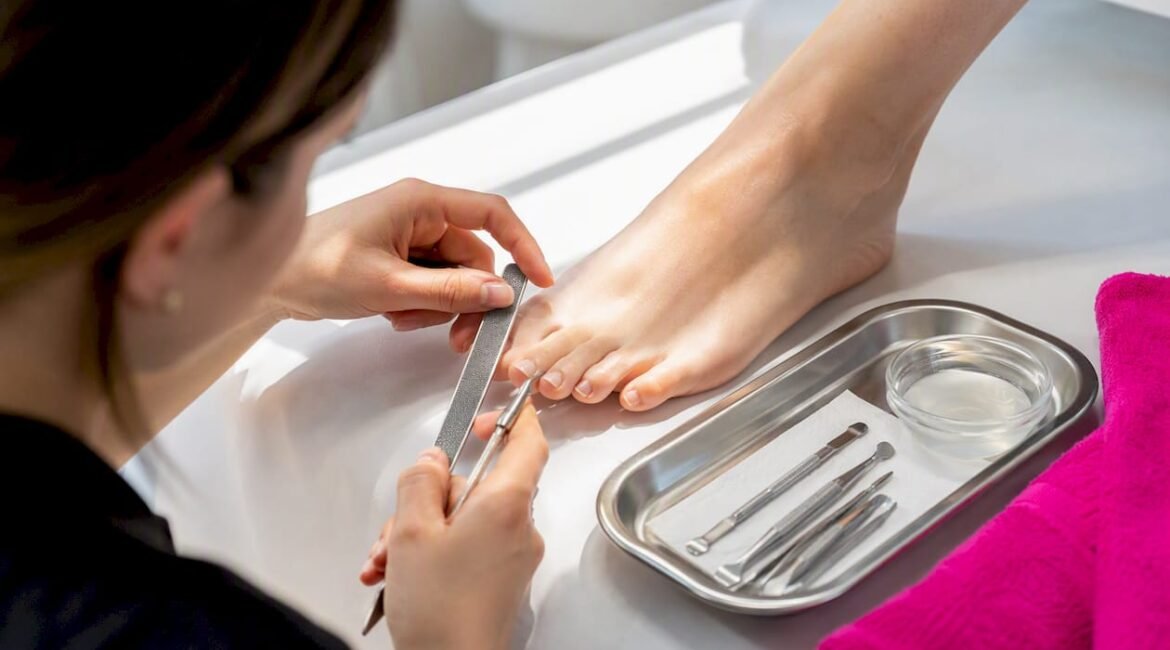 Mani che si preparano a prendersi cura dei piedi con strumenti per la pedicure