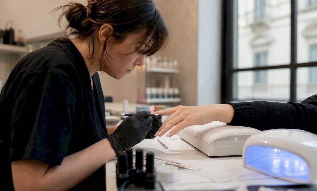 Mani che applicano gel per unghie durante una lezione a Milano
