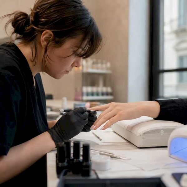 Mani che applicano gel per unghie durante una lezione a Milano