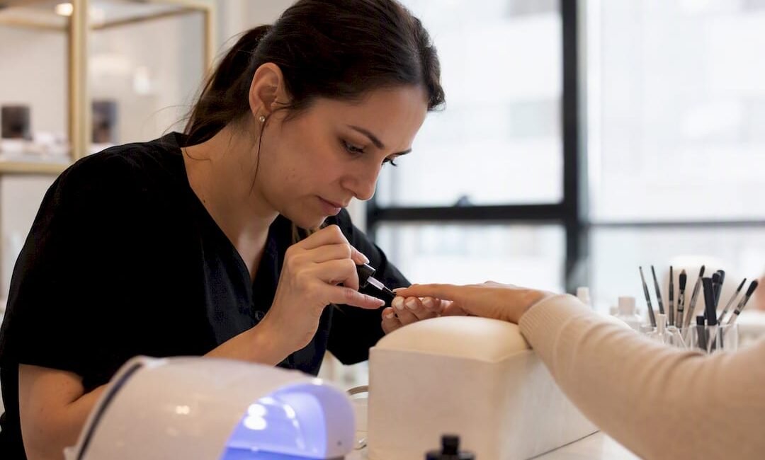 Mani che applicano gel per unghie in un'accademia di Milano